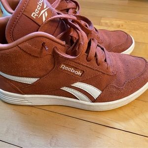 Rust colored Reebok women’s mid top shoe.